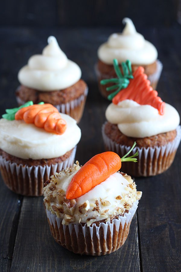 Cupcakes topped with three different types of sugar candy carrots