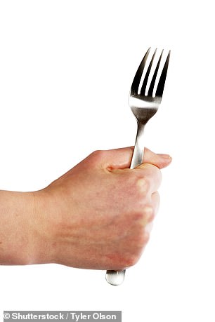 Gripping your fork in your hand will have others frowning at your table manners during festive dinner parties (stock image)