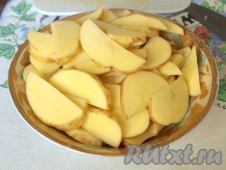 Нарезать ломтиками очищенный картофель.
