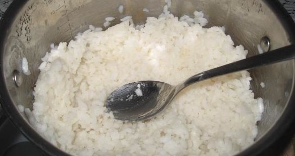 вареный рис в миске с ложкой